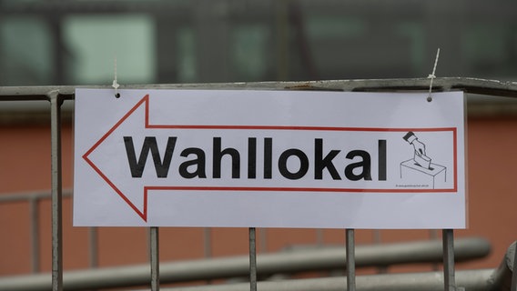 Ein Schild macht auf ein Wahllokal aufmerksam © picture alliance/dpa Foto: Paul Zinken