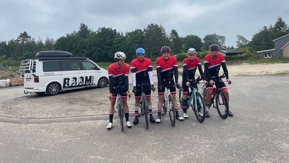 Eine Gruppe von Radfahrern stehen mit ihrem Rädern für ein Gruppenfoto auf einem Parkplatz © Sören Sönksen Foto: Sören Sönksen