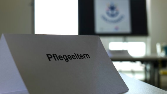 Auf einem Schild steht das Wort "Pflegeeltern". © NDR Foto: Margarita Ilieva