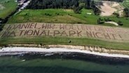 Auf einem Feld steht in überdimensionaler Schrift: "Daniel, wir wollen deinen Nationalpark nicht!" © Carsten Marquardt 