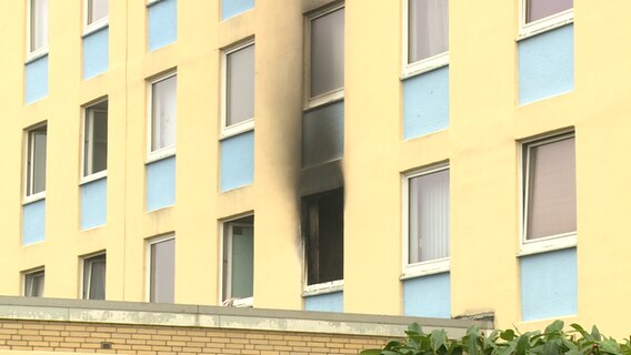 In einem Hochhaus in Wedel sind nach einem Brand Rußrückstände an einem Fenster zu sehen.  