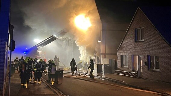 Feuerwehrleute löschen den Brand in einem Haus in Heide, aus dem es stark qualmt. © Westküstennews Foto: Simon Pfeiffer