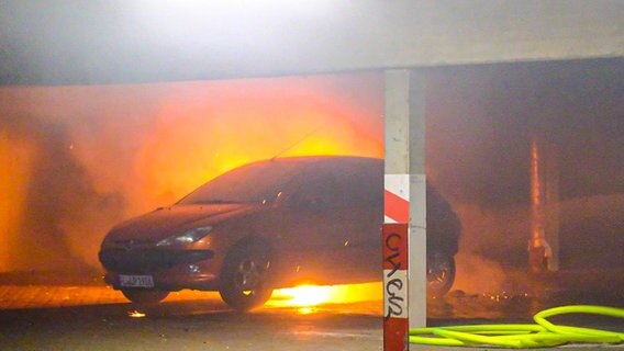 Ein Auto brennt in einem Parkhaus. © NDR 