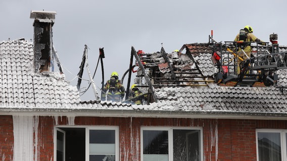 Feuerwehrleute löschen einen Dachstuhlbrand in Pinneberg. Überall klebt Löschschaum. © westküstennews 