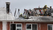 Feuerwehrleute löschen einen Dachstuhlbrand in Pinneberg. Überall klebt Löschschaum. © westküstennews 