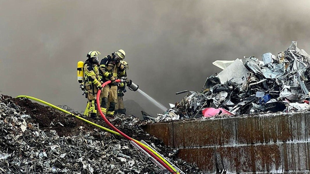 Einsatzkräfte der Feuerwehr löschen einen Brand auf einem Recyclinghof in Reinbek.