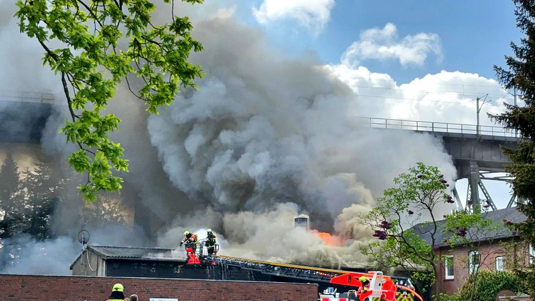 Rauch eines Lagerhallenbrandes umhüllt die Rendsburger Eisenbahnhochbrücke.