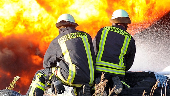 Zwei Feuerwehrleute bekämpfen einen Brand (Symbolbild). © dpa-Zentralbild Foto: Robert Schlesinger