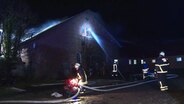 Einsatzkräfte der Feuerwehr löschen einen brennenden Hof in Stubben. © TNN 