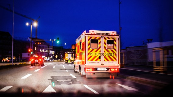 Ein Einsatzfahrzeug des Rettungsdienstes ist bei Dämmerung auf einer Straße in Kiel unterwegs. © Feuerwehr Kiel 