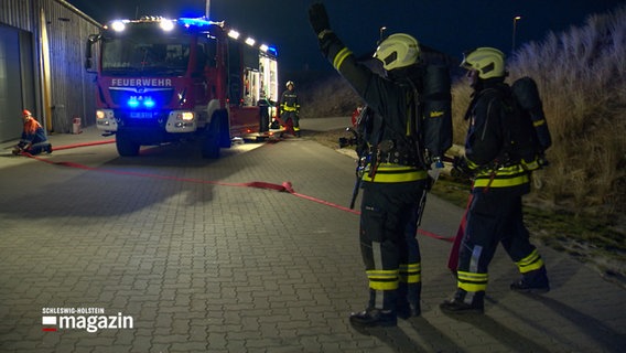 Einsatzkräfte der Feuerwehr führen eine Übung durch. © NDR 