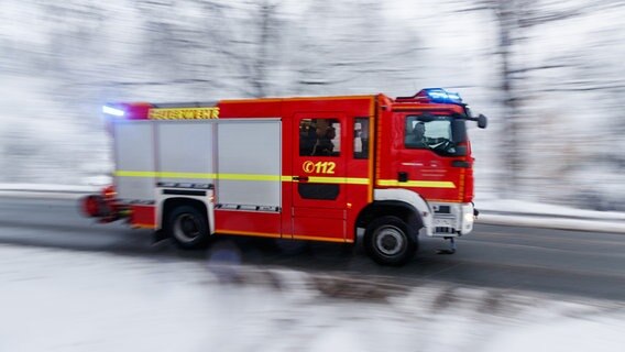 Ein Feuerwehrauto, welches durch den Schnee fährt. © picture alliance/dpa Foto: Friso Gentsch
