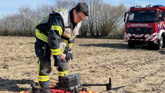 Ein Feuerwehrmann startet eine Drohne mit Wärmebildkamera. © NDR Foto: Jochen Dominicus