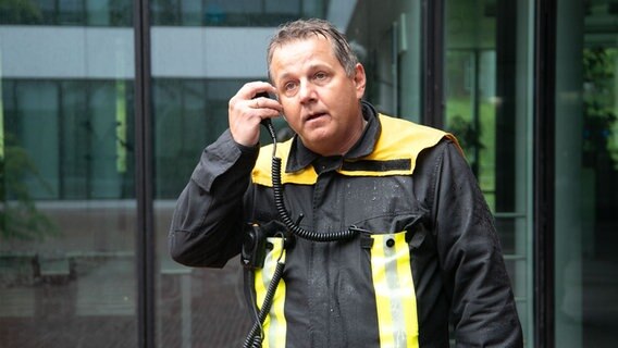 Ein Feuerwehrmann erhält Informationen über Funk. © NDR Foto: Marina Heller