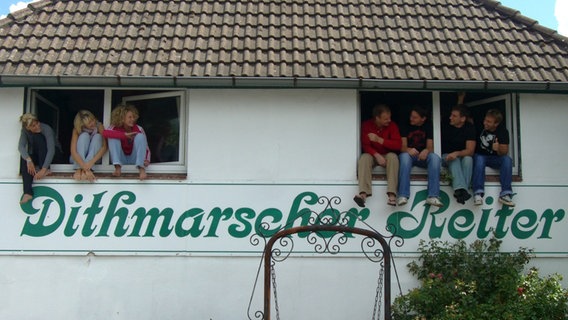 Foto aus dem Jahr 1993. Mehrere Personen schauen aus einem Haus aus zwei Fenstern © Hans-Dieter Ruge, FH Westküste 