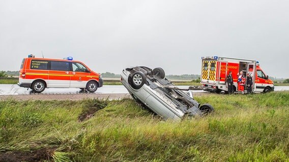 Notarzt und Rettungswagen bei Verkehrsunfall. Ein Auto liegt auf dem Dach. © NDR Foto: Benjamin Nolte