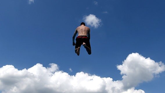 Ein Mann springt im Freibad von Neumünster vom 3-Meter-Brett © dpa - Bildfunk Foto: Carsten Rehder