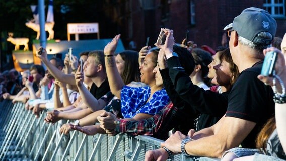 Ein Konzertpublikum hebt die Hände und filmt mit Smartphones die Bühne. © NDR Foto: Julia Jänisch