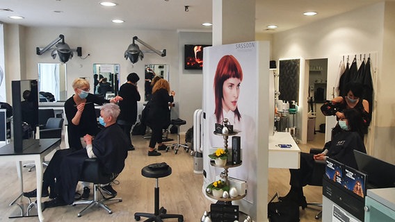 Mehrere Kunden eines Friseursalons werden frisiert. © NDR Foto: Sebastian Parzanny
