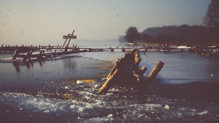 Die Sicht auf gefrohrenes Wasser mit Pfählen, die aus dem Eis ragen. © Familie Wiederich Foto: Familie Wiederich