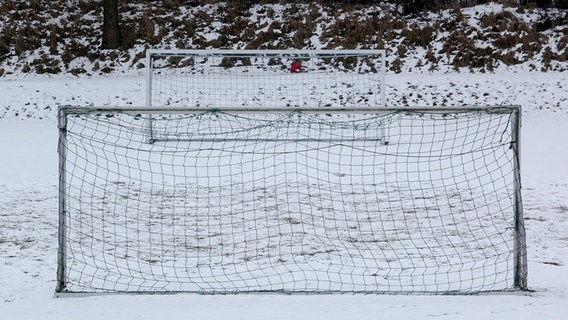 Fußballtore stehen auf einem schneebedeckten Fußballplatz. © dpa Foto: Carsten Rehder