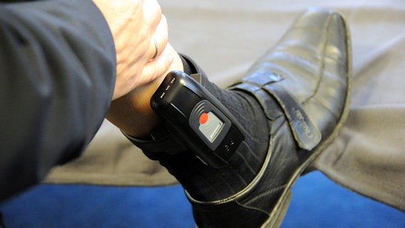 Elektronische Fußfessel an einem Bein © +++(c) dpa - Bildfunk+++ Foto: Carsten Rehder
