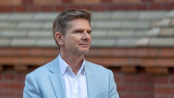 FDP-Politiker Heiner Garg steht vor einer Steinwand. © NDR Foto: Janis Röhlig