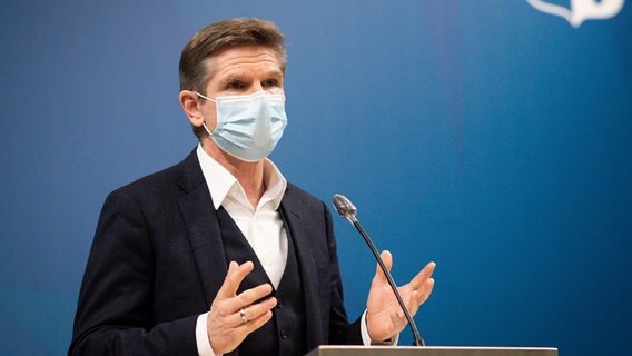 Heiner Garg steht mit Gesichtsmaske an einem Rednerpult. © dpa/picture alliance Foto: Christian Charisius