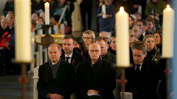 Bundeskanzler Olaf Scholz (erste Reihe, l-r, SPD) und Peter Tschentscher (SPD), Erster Bürgermeister von Hamburg, und Daniel Günther (CDU), Ministerpräsident von Schleswig-Holstein, nehmen am Trauergottesdienst für die Opfer der Messerattacke in einem Regionalzug von Kiel nach Hamburg teil. © dpa-Bildfunk Foto: Marcus Brandt