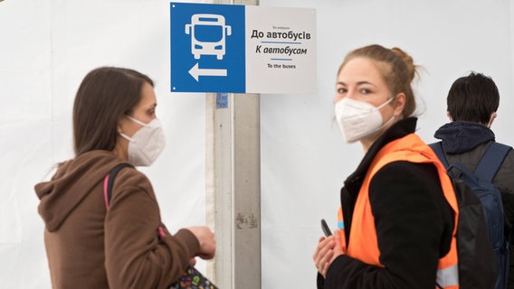 Mehrere Personen tragen einen Mundschutz im Willkommenszelt für ukrainische Kriegsflüchtlinge am Berliner Hauptbahnhof © imago images Foto: Stefan Trappe