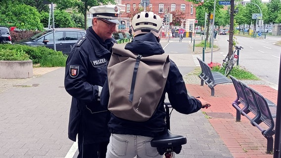 Ein Polizist spricht mit einem Radfahrer. © Polizeidirektion Kiel 