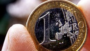 Eine Euromünze zwischen zwei Fingern © dpa/lmv Foto: Jens Büttner