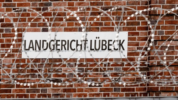 Die Aufschrift "Landgericht Lübeck" hinter Maschendrahtzaun. © dpa-Bildfunk Foto: Markus Scholz/dpa