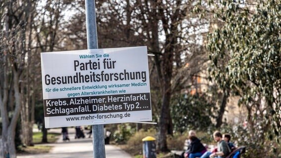 Ein Wahlplakat der Partei für gesundheitsforschung hängt an einer Laterne. © IMAGO / Arnulf Hettrich Foto: Arnulf Hettrich