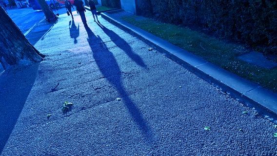 Laufende Menschen werfen in der Dämmerung lange Schatten auf den Gehweg. © Imago Images / Rolf Poss Foto: Imago Images / Rolf Poss