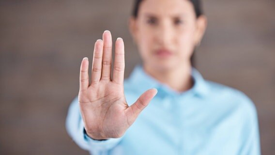 Eine Frau hält ihre Handfläche an ausgestrecktem Arm in die Kamera. © imago images / Zoonar Foto: Zoonar