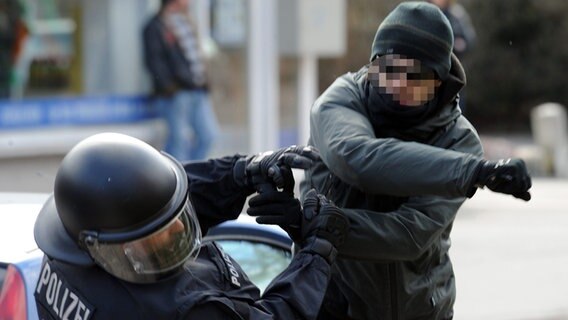 Ein gewalttätiger Demonstrant schlägt einen Polizeibeamten nieder. © picture alliance Foto: Carsten Rehder