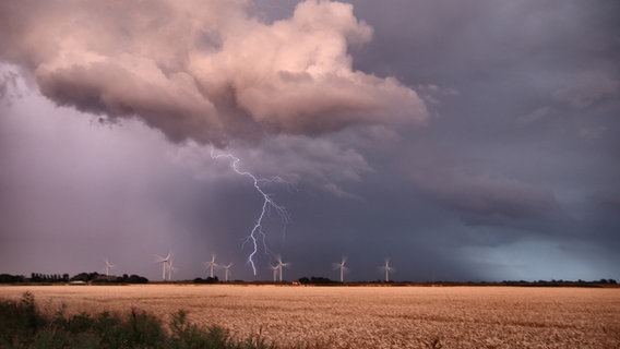 Ein Blitz ist zwischen Gewitterwolken am dunklen Himmel zu erkennen. © Michaela Peter Foto: Michaela Peter