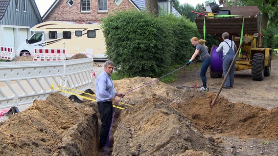 Bürger aus Rendsburg buddeln einen Graben, um dort eine Glasfaserleitung zu legen. © NDR 