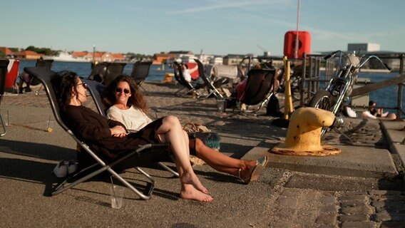 Zwie Frauen genießen den Ausblick auf einen Hafen. © NDR Foto: Andreas Bell