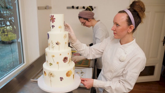 Die Konditorin verziert eine Torte. © NDR 