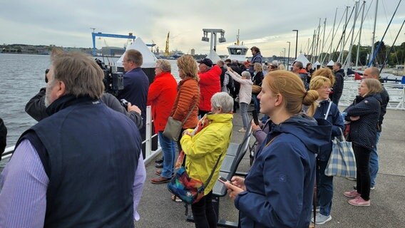Zahlreiche Menschen stehen an der Kieler Förde und beobachten die Ankunft der "Gorch Fock".  Foto: Kai Peuckert