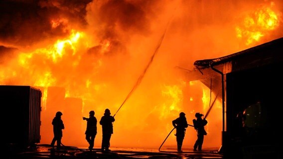 Feuerwehrleute löschen in Grambek auf einem Recyclinghof ein Feuer. © dpa - Bildfunk Foto: Christian Nimtz