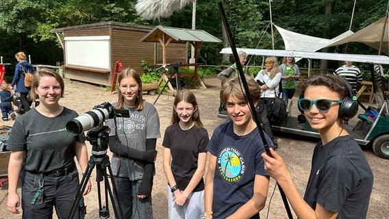 Vier Jugendliche und die Dozentin Almuth Ludwig (l.) stehen gemeinsam mit Film-Equipment im Wildpark Eekholt. © NDR Foto: Samir Chawki