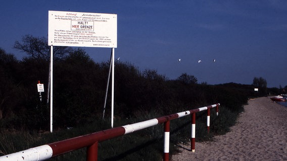 Eine Hinweistafel an der Pötenitzer Wiek am Priwall weißt auf die Grenze zwischen der DDR und der BRD hin. © www.grenzbilder.de Foto: Jürgen Ritter