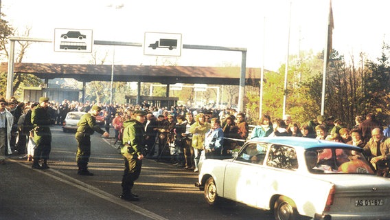 Menschenmaßen stehen am Straßenrand und beobachten Autos am Grenzübergang Schlutup. © NDR Foto: Friedrich Keller