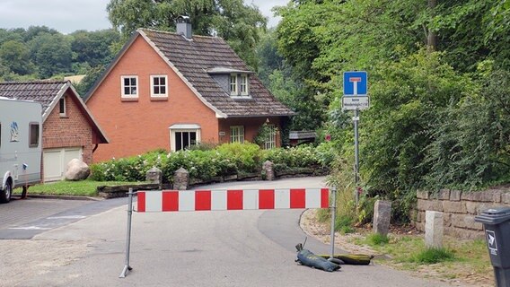Ein Verkehrsschild weist auf eine Sackgasse in Niehuus hin. Davor ist eine rot-weiße Sperre aufgebaut. © NDR Foto: Peer-Axel Kroeske