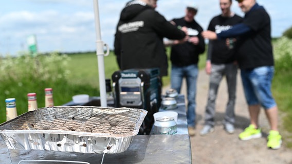 Hinter einem vollgepackten Bollerwagen stößt eine Gruppe Männer auf den Vatertag 2023 an. © picture alliance/dpa Foto: Lars Klemmer