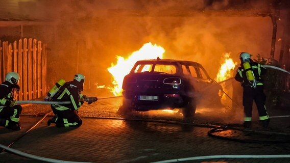 Feuerwehrleute löschen brennendes Auto unter Carport in Grömitz © Digitalfotografie Nyfeler & Jappe Foto: Arne Jappe