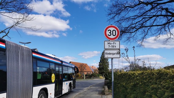 Tempo-30 Beschilderung mit Hinweis auf einen Kindergarten. Bus fährt an Schild vorbei © Pia Klaus 